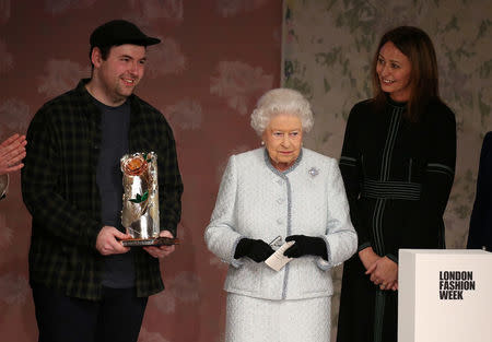 Britain's Queen Elizabeth II presents the inaugural Queen Elizabeth II Award for British Design to Richard Quinn as Caroline Rush, Chief Executive of the British Fashion Council looks on after his show at London Fashion Week , in London, Britain February 20, 2018. REUTERS/Paul Hackett