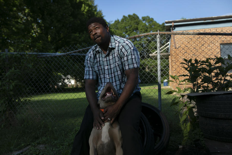 La Jarvis D. Love strokes one of several dogs he keeps at his home in Senatobia, Miss., Sunday, June 9, 2019. Love says the dogs protect his wife and three children. (AP Photo/Wong Maye-E)