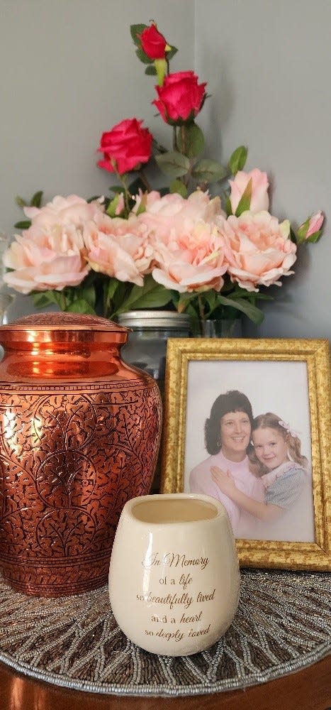 A framed photo of Karen Moore and her daughter, Christina Baber. Karen Moore was reported missing June 2001 in Davie, Florida after not showing up for work or picking up Baber from Girl Scout camp. In January 2023, a couple divers found Moore's Saturn and human remains at the bottom of a pond, giving Baber closure.