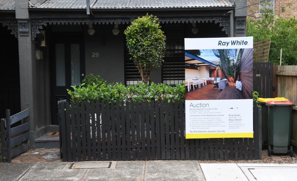 An advertising board for an upcoming auction sits outside a house. (Source: Getty)