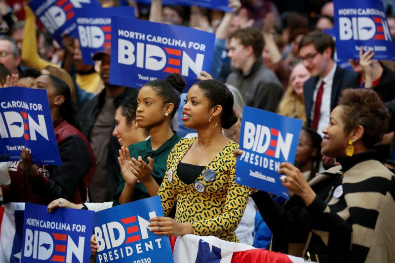 People wave campaign signs during an event with Democratic U.S. presidential candidate and former U.S. Vice President Joe Biden at Saint Augustine's University in Raleigh