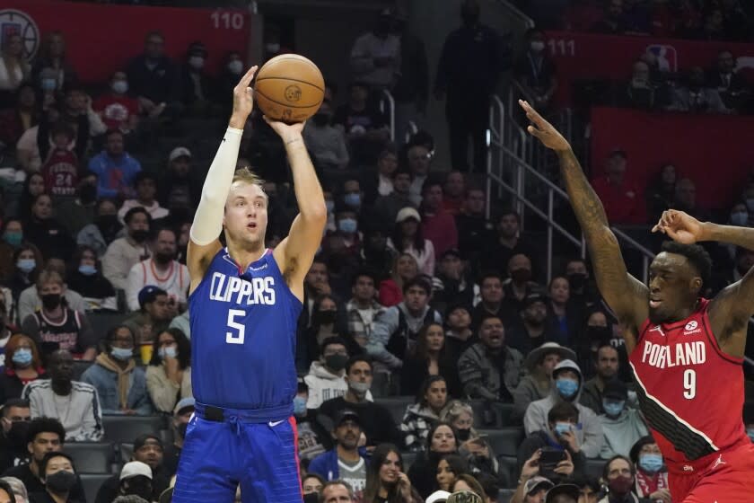 Los Angeles Clippers' Luke Kennard, left, makes a three-point basket next to Portland Trail Blazers forward Nassir Little (9) during the first half of an NBA basketball game Monday, Oct. 25, 2021, in Los Angeles. (AP Photo/Marcio Jose Sanchez)