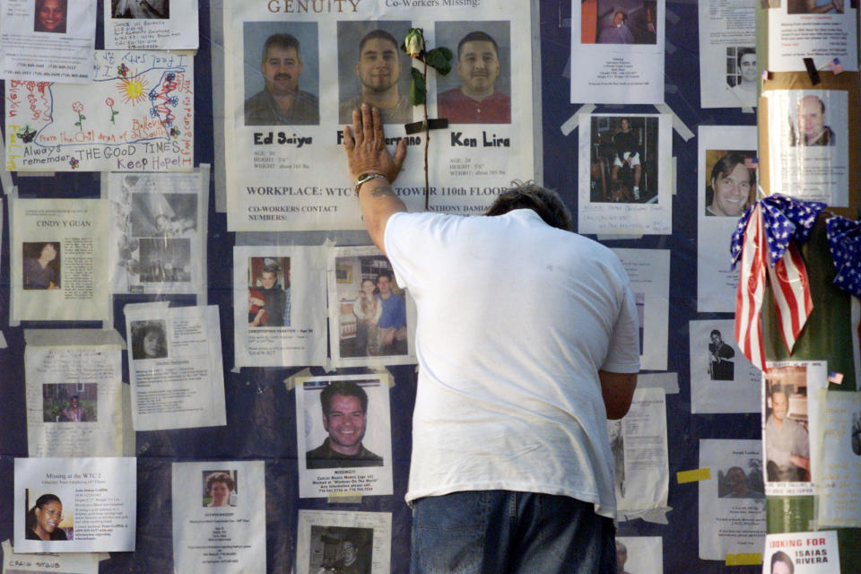 A man places his hand on a wall showing photos of missing people
outside Bellevue Hospital in New York September 16, 2001. Family and
friends of people missing since the collapse of the World Trade Center
have been posting photos of their loved ones. (Russell Boyce/Reuters)


