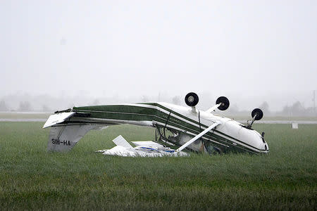 A plane that was flipped by strong winds from Cyclone Debbie is seen at the airport in the town of Bowen. AAP/Sarah Motherwell/via REUTERS
