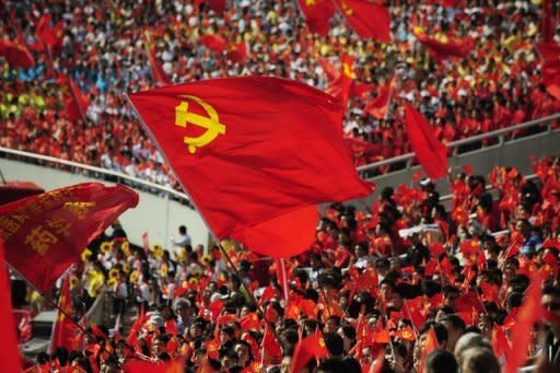 Chinese wave flags as they celebrate the 90th anniversary of the Communist Party of China in Chongqing. A Chinese official sentenced without trial to hard labour for opposing the Maoist revival policies of disgraced politician Bo Xilai has been freed and is seeking compensation, his lawyer has told AFP