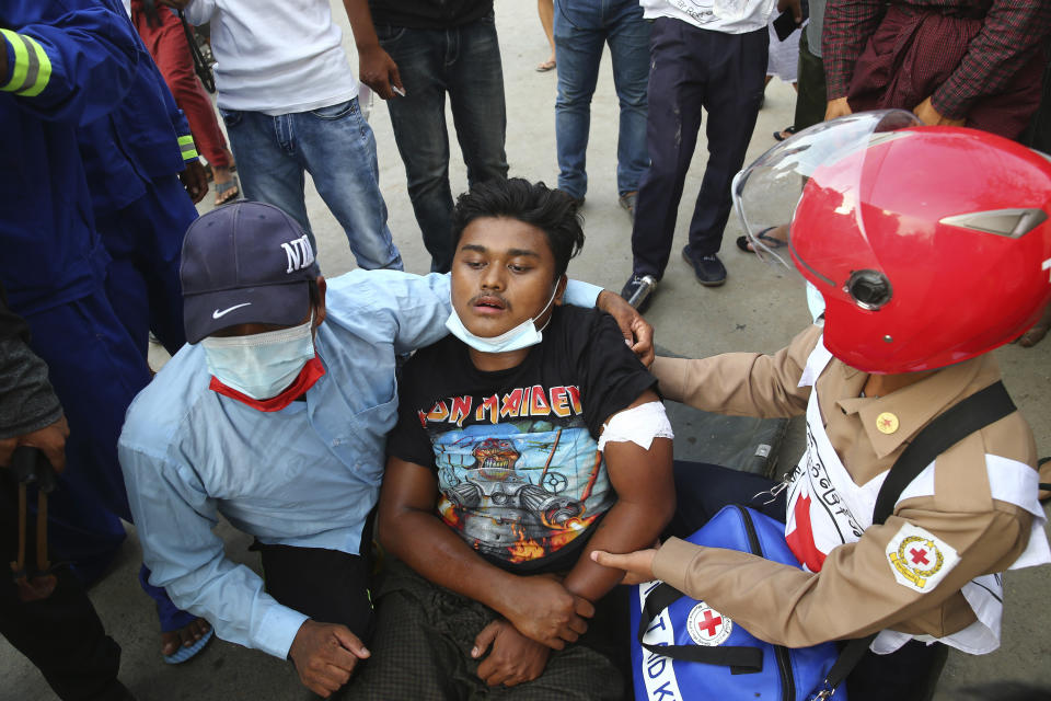 A man is provided with first aid during a protest in Mandalay, Myanmar on Saturday, Feb. 20, 2021. Security forces in Myanmar ratcheted up their pressure against anti-coup protesters Saturday, using water cannons, tear gas, slingshots and rubber bullets against demonstrators and striking dock workers in Mandalay, the nation's second-largest city. (AP Photos)