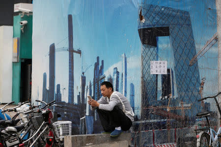 A worker rests outside a construction site in Beijing's central business district, China, July 15, 2016. REUTERS/Jason Lee