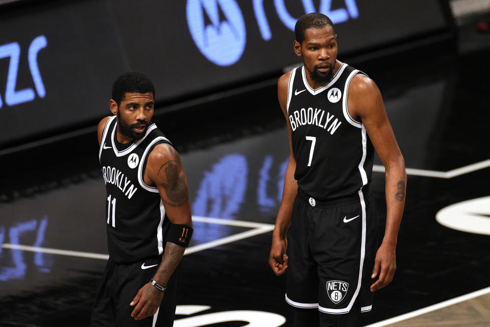 Kyrie Irving and Kevin Durant look down the court during a game.