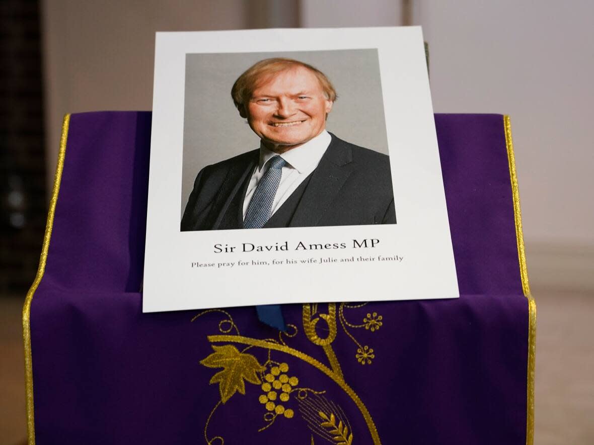 An image of slain British MP David Amess is displayed near the altar in St. Peter's Catholic Church before a vigil in Leigh-on-Sea, England, on Friday.  (Alberto Pezzali/The Associated Press - image credit)