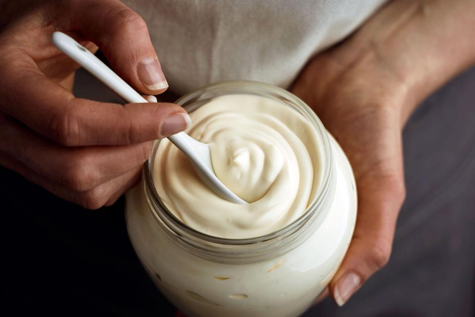 Jar of mayo being stirred with a spoon