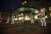 -FILE- In this Wednesday, Jan. 26, 2011, file photo, black patches representing oil spills are seen in the foreground as activists from Milieudefensie, the Dutch arm of the Friends of the Earth environmental organization dressed up as oil-covered birds, hold pictures outside the Shell headquarters in The Hague, Netherlands. A landmark legal battle opens in The Hague, Tuesday Dec. 1, 2020, as climate change activists in the Netherlands go to court seeking an order for energy giant Shell to rein in its carbon emissions. (AP Photo/Peter Dejong)