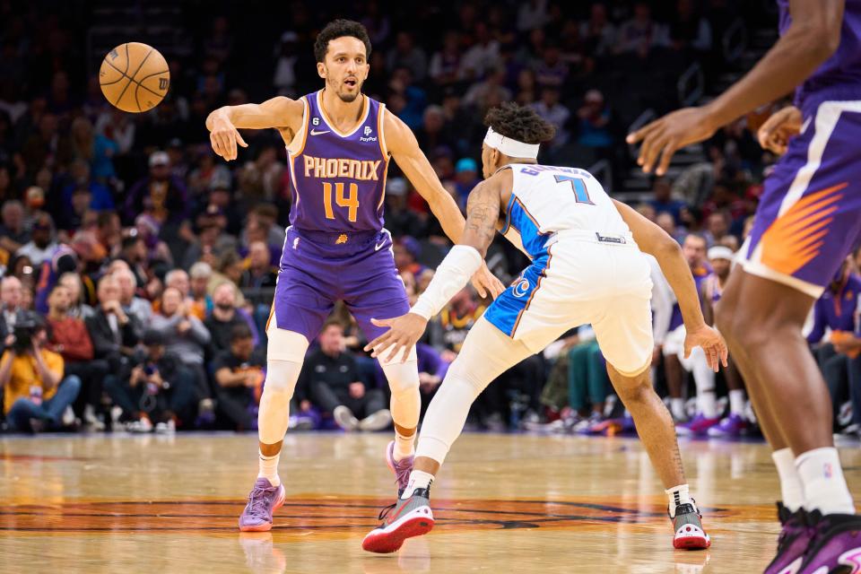 Phoenix Suns guard Landry Shamet (14) passes the ball while being guarded by Washington Wizards guard Jordan Goodwin (7) at Footprint Center on Tuesday, Dec. 20, 2022.