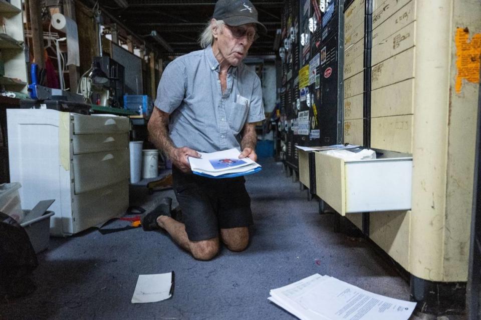 William Dause, who started the Parachute Center in 1981 and still works there, shows off photographs and other records in September.