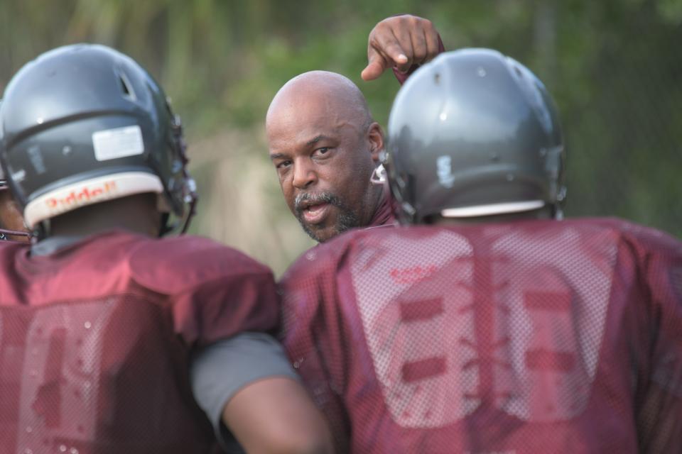 Palm Beach Lakes first-year head coach Cedric Jones runs practice, motioning to a few of his players in the huddle as he calls plays during contact drills on Aug. 11, 2022.