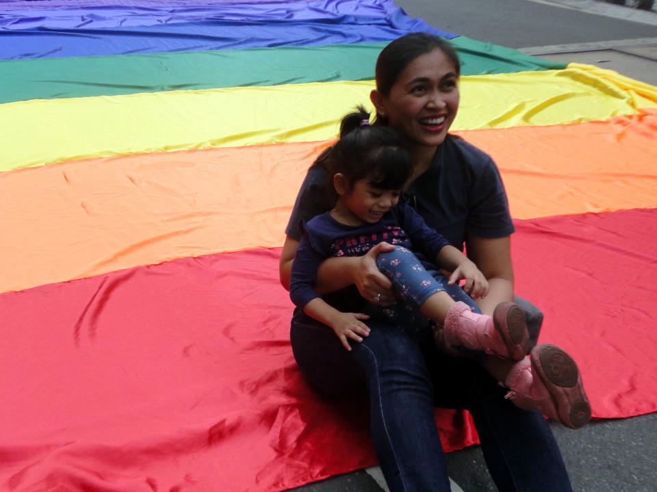 A Filipino woman sits on a rainbow flag with her child during a Gay Pride event in Quezon City, east of Manila, Philippines, in 2015. Hundreds of Lesbian, Gay, Bisexual, and Transgender (LGBT) advocates and supporters gathered in the event to show their presence and to demand LGBT rights. (Photo by Richard James Mendoza/Pacific Press/LightRocket via Getty Images)