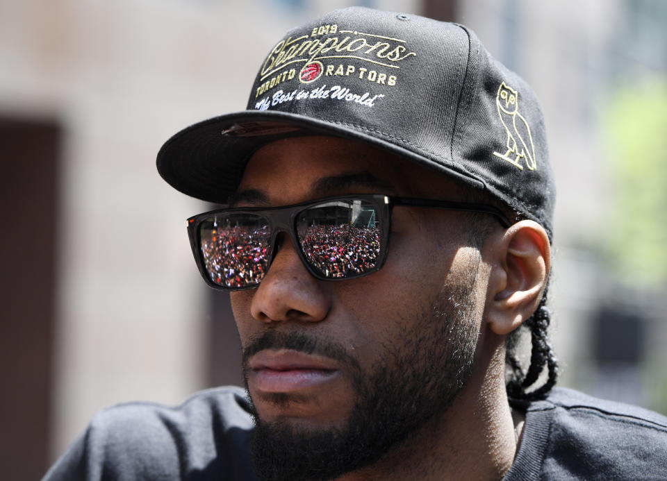 The crowd is reflected in Toronto Raptors forward Kawhi Leonard's sunglasses as he celebrates during the NBA basketball championship team's victory parade in Toronto, Monday, June 17, 2019. (Frank Gunn/The Canadian Press via AP)