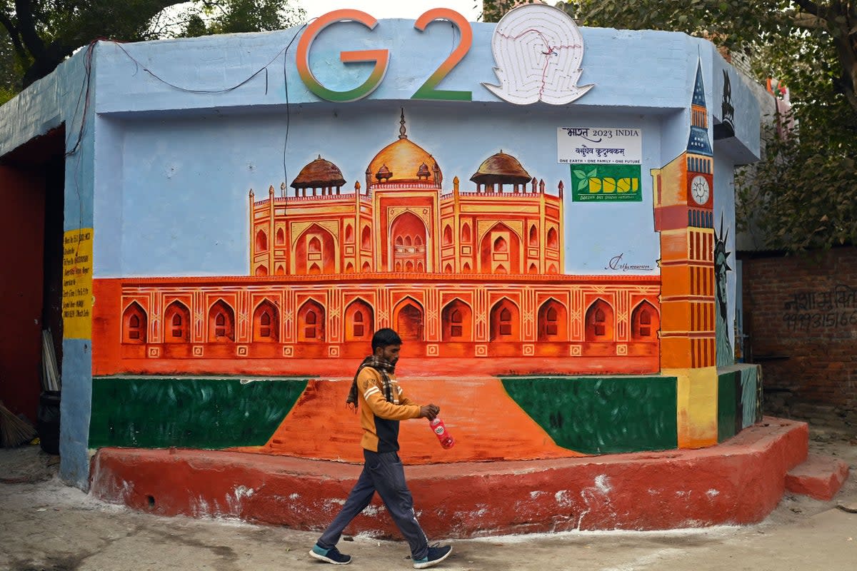 A man walks past a wall mural of Humayun’s tomb under the logo of G-20 Summit, in New Delhi (AFP via Getty Images)