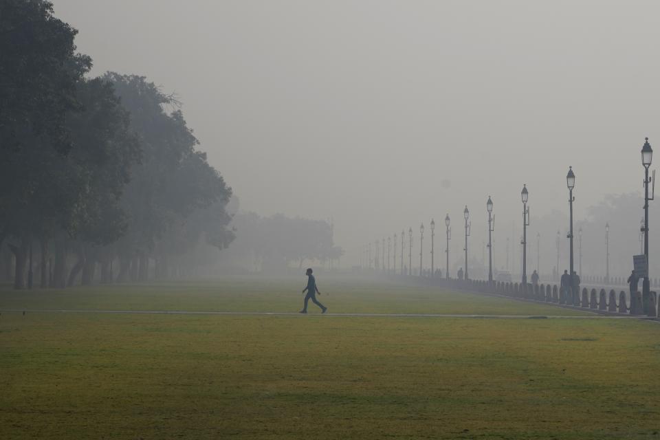 FILE - A man walks, enveloped by smog early morning in New Delhi, India, Dec. 13, 2023. Under certain wind directions, about 30% of Delhi's pollution can come from Punjab province in Pakistan. (AP Photo/Manish Swarup, File)