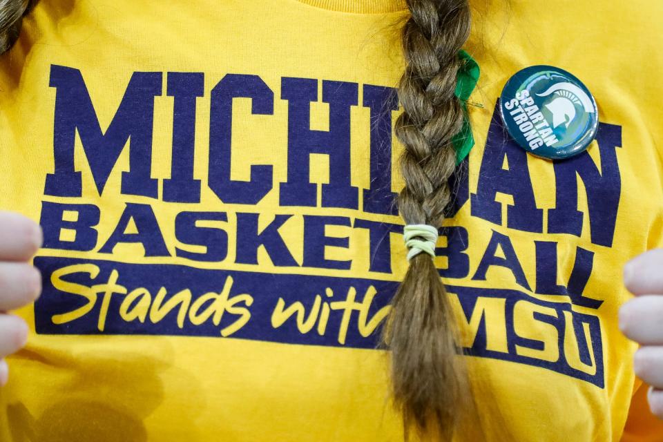 U-M sophomore Emma Mellott shows off the green ribbon and Spartan Strong sticker for support of the MSU community before the Michigan State game at Crisler Center in Ann Arbor on Saturday, February 18, 2023.