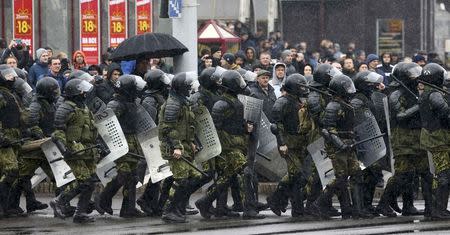 Law enforcement officers walk during a gathering, denouncing the new tax on those not in full-time employment and marking the 99th anniversary of the proclamation of the Belarussian People's Republic, in Minsk, Belarus, March 25, 2017. REUTERS/Vasily Fedosenko