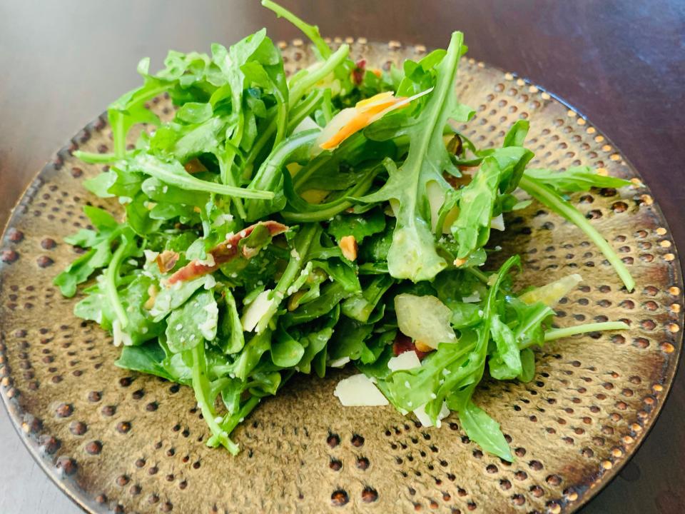 Trader Joe's lemony arugula salad plated on a brown spotted plate