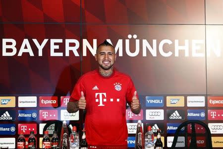 Chile's Arturo Vidal, Bayern Munich's new signing, gives thumbs up as he tries out his new jersey at the Allianz Arena in Munich, Germany July 28, 2015. Vidal has completed his transfer from Juventus to Bayern Munich by signing a four-year contract with the Bundesliga champions. REUTERS/Michaela Rehle