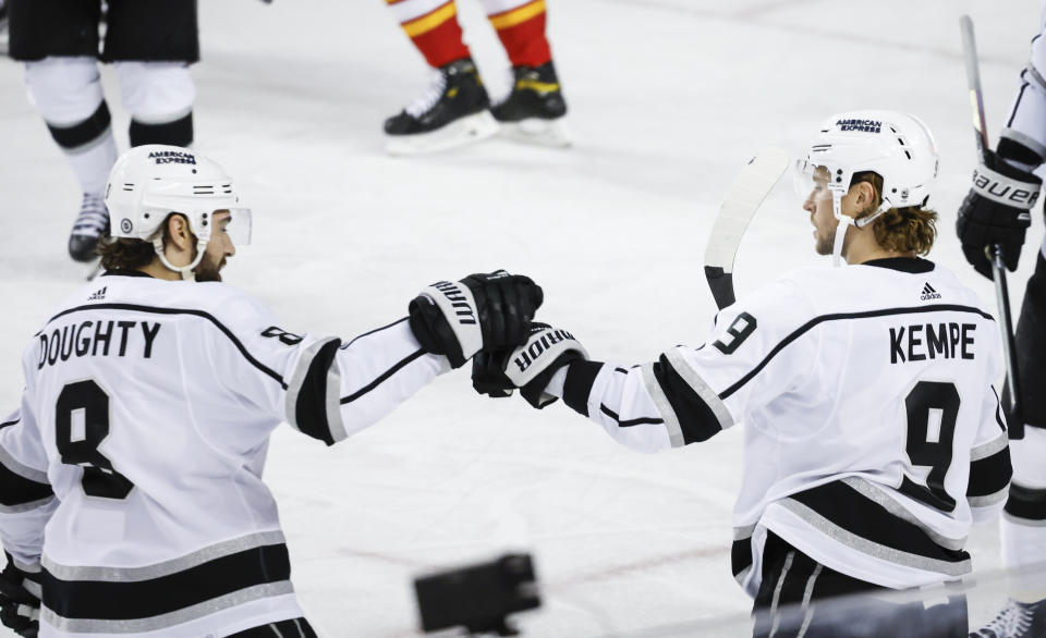 Los Angeles Kings forward Adrian Kempe (9) celebrates his goal against the Calgary Flames with defenseman Drew Doughty (8) during the first period of an NHL hockey game Saturday, March 30, 2024, in Calgary, Alberta. (Jeff McIntosh/The Canadian Press via AP)
