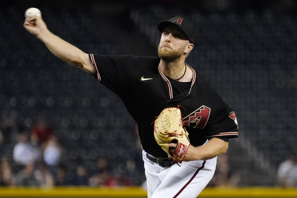 Arizona Diamondbacks starting pitcher Merrill Kelly throws against the Atlanta Braves during the first inning of a baseball game, Wednesday, Sept. 22, 2021, in Phoenix. (AP Photo/Matt York)