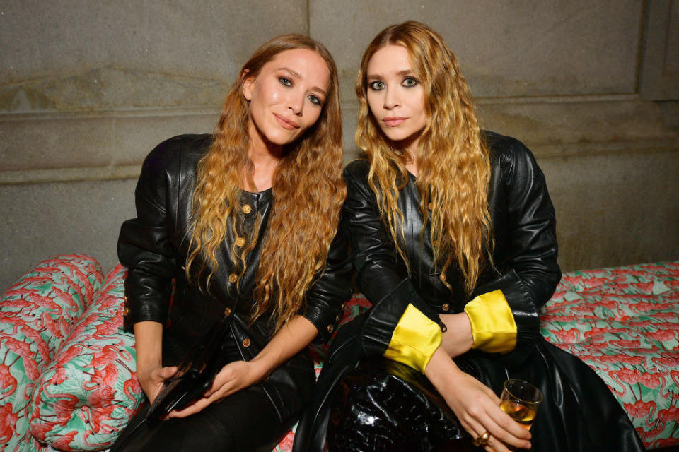 Mary-Kate and Ashley Olsen, as adults, pose for a photo together wearing matching outfits