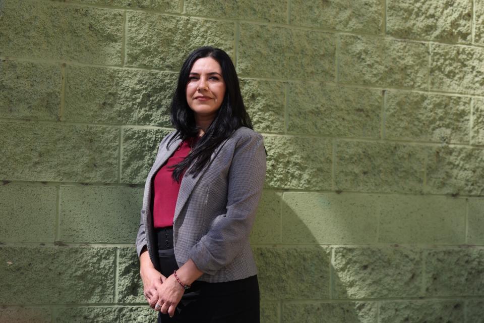 L.A. Unified counselor Belinda Barragan poses for a portrait in front of a brick wall.
