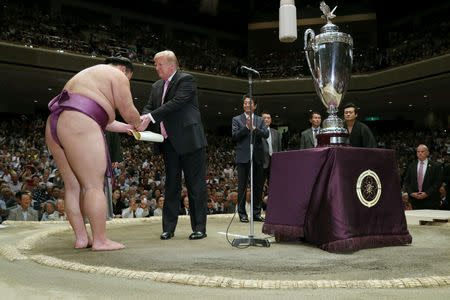 U.S. President Donald Trump prepares to present the President’s Cup to wrestler Asanoyama, the winner of the Summer Grand Sumo Tournament at Ryogoku Kokigikan Sumo Hall in Tokyo, Japan May 26, 2019. REUTERS/Jonathan Ernst