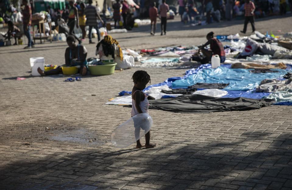 A child plays with an inflated condom at the Hugo Chavez public square transformed into a refuge for families forced to leave their homes due to clashes between armed gangs in Port-au-Prince, Haiti, Thursday, Oct. 20, 2022. (AP Photo/Odelyn Joseph)