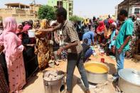 Volunteer distributes food to people in Omdurman