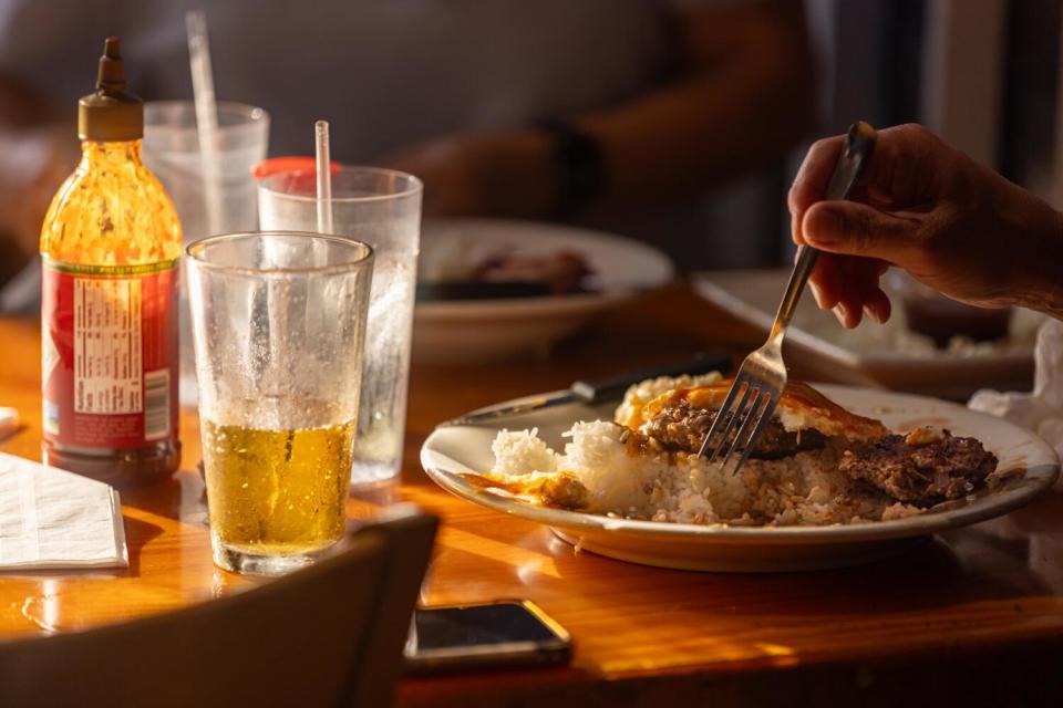 A diner digs into food at Back Home in Lahaina.