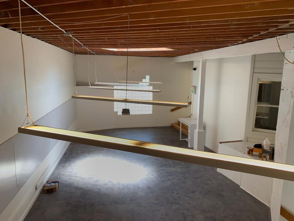 an empty office space with lights hanging from the ceiling