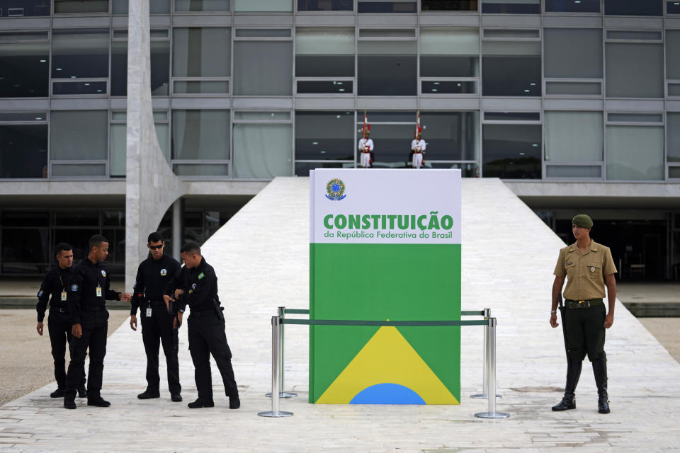 Soldiers stand guard outside Planalto presidential palace, where a large replica of the Brazilian Constitution is on display, on the one year anniversary of riots in support of outgoing, former President Jair Bolsonaro in Brasilia, Brazil, Monday, Jan. 8, 2024. Rioters stormed the presidential palace, Congress and the Supreme Court buildings, and Bolsonaro has been under investigation by the Supreme Court over his role in the mayhem. (AP Photo/Eraldo Peres)