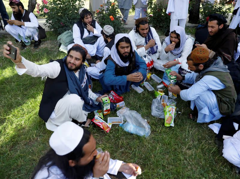 FILE PHOTO: A newly freed Taliban prisoner takes a selfie as other have juice and biscuits at Pul-i-Charkhi prison, in Kabul, Afghanistan