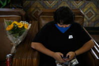 Miguel Gomez, 20, waits for a train next to his flowers at Union Station in Los Angeles, Monday, July 6, 2020. The coronavirus is blamed for over a half-million deaths worldwide, including more than 130,000 in the U.S., according to the tally kept by Johns Hopkins University. (AP Photo/Jae C. Hong)