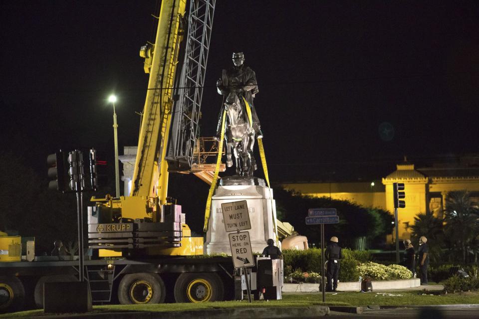 Workers attach straps to a statue P.G.T. Beauregard