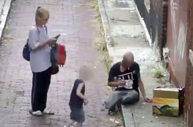 Unbelievable footage shows a mother injecting heroin in an alleyway with a man, while her son plays on a mobile phone nearby. Picture: Cincinnati Police Department