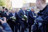 German Interior Minister Horst Seehofer and Saxony-Anhalt State Premier Reiner Haseloff hold flowers outside a synagogue in Halle