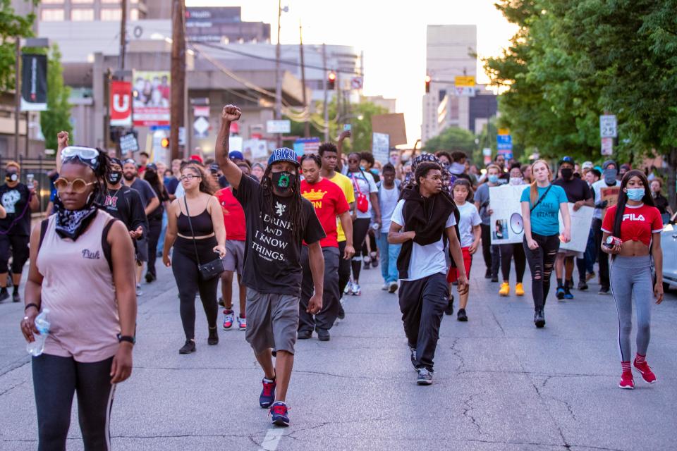 Protesters make their way through downtown Louisville during a demonstration on June 16, 2020.