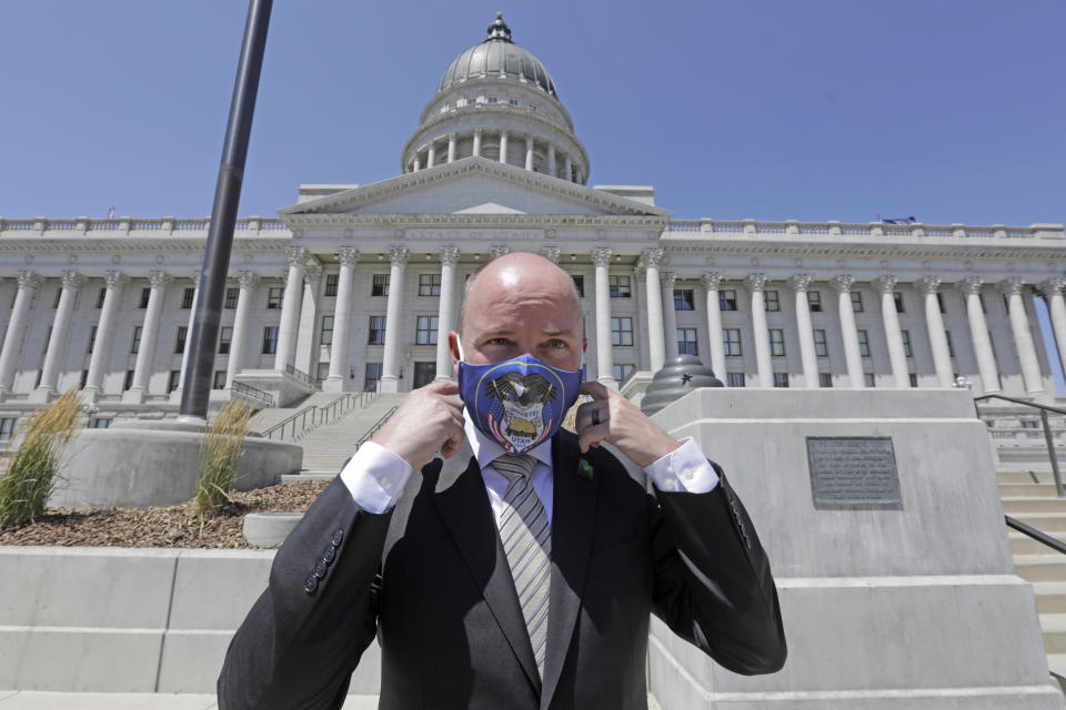 Lt. Gov Spencer Cox adjusts his face mask as he poses for a photograph at the Utah state Capitol Tuesday, July 7, 2020, in Salt Lake City. Jon Huntsman Jr. was narrowly beaten Monday by Cox, who had heightened visibility as he helped respond to the coronavirus and managed to pitch himself as an earnest politician with rural Utah roots. (AP Photo/Rick Bowmer)