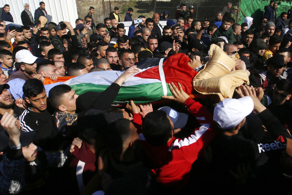 Palestinians carry the body of Yazan Abu Tabekh during his funeral in the West Bank city of Jenin, Thursday, Feb. 6, 2020. The 19-year-old Palestinian was killed in clashes with Israeli troops, according to Palestinian hospital officials. (AP Photo/Majdi Mohammed)