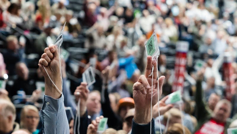 Attendees raise their credentials to vote during the Utah Republican Party Organizing Convention at Utah Valley University in Orem on April 22, 2023.