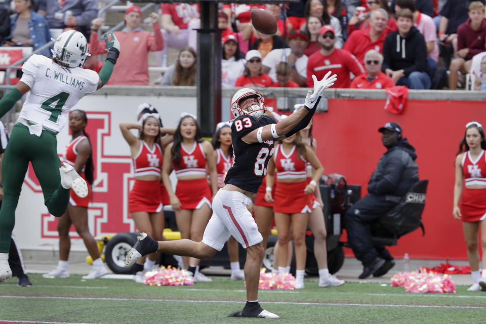 Houston wide receiver Peyton Sawyer (83) makes a pass reception to score past South Florida safety Christian Williams (4) during the first half of an NCAA college football game Saturday, Oct. 29, 2022, in Houston. (AP Photo/Michael Wyke)