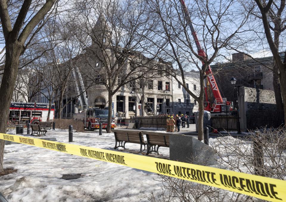 Firefighters continue the search for victims Monday, March 20, 2023 at the scene of last week's fire in Montreal. Montreal’s mayor is vowing to better regulate Airbnb in her city as the search continues for six people missing through a building that included Airbnb units in a historic city section where they are banned. (Ryan Remiorz/The Canadian Press via AP)