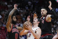 Miami Heat forward Jaime Jaquez Jr. (11) attempts a shot against Chicago Bulls guard Coby White (0) and center Nikola Vucevic during the first half of an NBA basketball play-in tournament game, Friday, April 19, 2024, in Miami. (AP Photo/Wilfredo Lee)