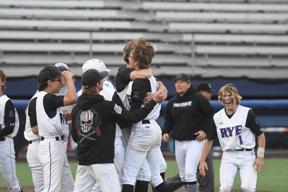 Rye High School head coach Clay Klipfel (second from right) celebrates  with his team after the Thunderbolts walked off Dawson School on Sunday at Rawlings Field to win their Class 2A regional. Rye defeated Dawson 8-7. [Chieftain photo/Jeff Letofsky]