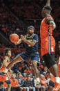 Michigan's Zavier Simpson (3) passes around Illinois defender Kofi Cockburn (21) in the second half of an NCAA college basketball game, Wednesday, Dec. 11, 2019, in Champaign, Ill. (AP Photo/Holly Hart)